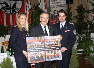 Anja Aldermann und Robert Buder überreichen Landrat Harald Altekrüger (Mitte) eine Collage der Feuerwehr-WM. Als Dank für die Unterstützung der Finanzierung.