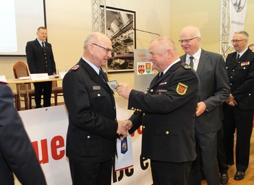 Der Präsident des Landesfeuerwehrverbandes, Werner-Siegwart Schippel, überreicht Siegmund Rückmann das Ärmelabzeichen als Ehrenmitglied