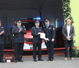 Der Vorstandsvorsitzende des Kreis&shy;feuerwehr&shy;verbandes Robert Buder überreicht die Jubiläumsurkunde (Mitte). Links: Gemeindewehrführer Steffen Theiler und der stellvertretende KBM Carsten Brudek. Rechts: Bürgermeister Karsten Schreiber