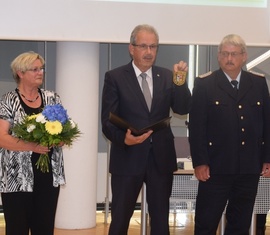 Landrat Harald Altekrüger (Mitte) präsentiert das neue Ärmelabzeichen, das Wolfhard Kätzmer ab Ende Juli tragen wird. Kreistagspräsidentin Monika Schulz-Höpfner (links) gratuliert ebenfalls.