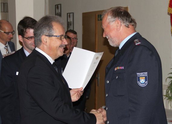 Landrat Harald Altekrüger übergibt die Urkunde an Wilfried Hoffmann