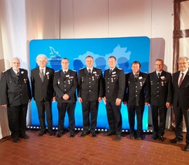 Landrat Harald Altekrüger (rechts) gratuliert den frisch Ausgezeichneten.