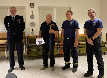 Immer gut behütet mit dem Schirm des Kreisfeuerwehrverbandes, den es zur Auszeichnung mit dazu gab. Überbracht vom Vorstand für Jugendarebeit Stefan Kothe. (links) Wehrführer Rico Nowka und sein Stellvertreter Nico Hammel gratulieren.