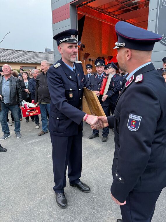 Marcel Reif (stellv. Ortswehrführer Döbern) überreicht Gastgeschenk an Olaf Hanusch (Ortswehrführer Halbendorf)