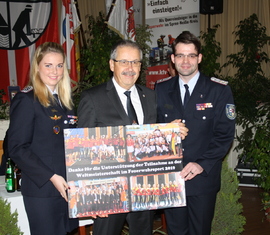 Anja Aldermann und Robert Buder überreichen Landrat Harald Altekrüger (Mitte) eine Collage der Feuerwehr-WM. Als Dank für die Unterstützung der Finanzierung.