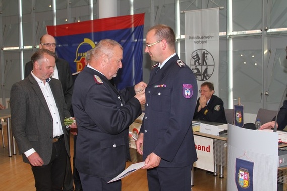 Werner-Siegwart Schippel zeichnet Marcel Bertram (OW Casel) mit Schiedsrichter- und Kampfrichterspange des Deutschen Feuerwehrverbandes in Bronze aus