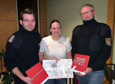 Robert Buder (Vorsitzender KFV), Nathalie Scherer (Brandenburgs beliebteste Brandschutzerzieherin) und Stefan Kothe (amt. Kreisjugendfeuerwehrwart) präsentieren die dt-polnischen Brandschutzfibeln