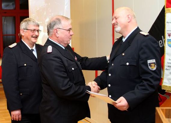 Stadtwehrführer Bernd Frommelt gratuliert dem ausgezeichneten Carsten Brudek.