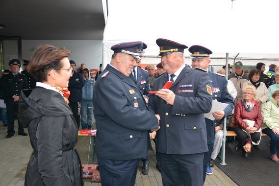 LFV-Präsident Werner-Siegwart Schippel zeigt Bernd Aßmus das Deutsche Feuerwehr-Ehrenkreuz in Gold, das bald an dessen Brust hängt. Links: Bürgermeisterin Birgit Zuchold, rechts: Kreisbrandmeister Stefan Grothe