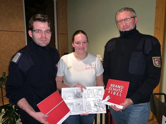 Robert Buder (Vorsitzender KFV), Nathalie Scherer (Brandenburgs beliebteste Brandschutzerzieherin) und Stefan Kothe (amt. Kreisjugendfeuerwehrwart) präsentieren die dt-polnischen Brandschutzfibeln