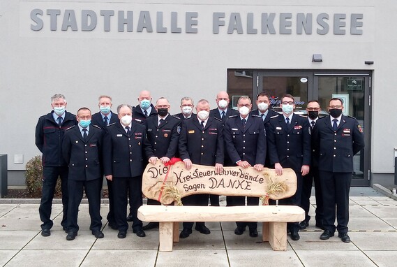 Die Vorsitzenden der Kreis- und Stadtfeuerwehrverbände schenken Werner-Siegwart Schippel eine Bank