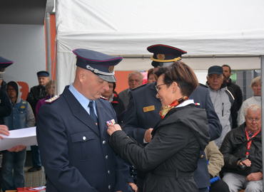 Bürgermeisterin Birgit Zuchold steckt Heino Wochnik die Ehrennadel der Deutschen Jugendfeuerwehr in Gold an.