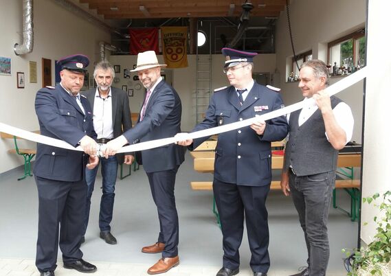 Mit dem Aufkoppeln eines C-Druckschlauches wurde das Feuerwehrgerätehaus in Müschen/Myšyn eingeweiht (v. l.): Ortswehrführer Marco Pfaffe, Bernd Ragotzky, stellvertretenden Bürgermeister von Burg (Spreewald)/Bórkowy (Błota), Amtsdirektor Tobias Hentschel, Amtswehrführer Marcus Weber und Ortsvorsteher Jens Quitz.