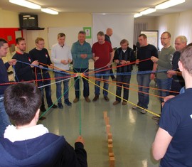 So viel wie möglich unregelmäßig geschnittene Holzklötze sollen mit vereinten Kräften gestapelt werden