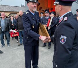 Marcel Reif (stellv. Ortswehrführer Döbern) überreicht Gastgeschenk an Olaf Hanusch (Ortswehrführer Halbendorf)