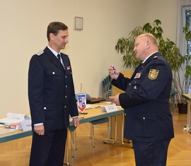 Kreisbrandmeister Stefan Grothe überreicht die Auszeichnung