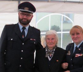 Ortswehrführer Manuel Marrack (l) und KFV Frauenbeauftragte Christine Semisch (r) zeichen Gründungsmitglied Margarete Rublack mit dem Ehrenzeichen des KFV SPN e.V. aus