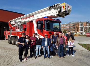 Gruppenbild vor dem Teleskopmast der LEAG Werkfeuerwehr in Schwarze Pumpe