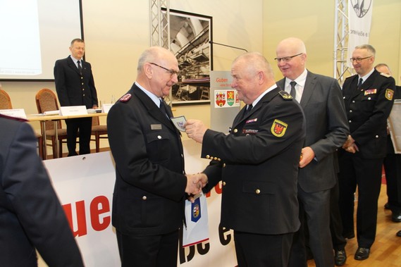 Der Präsident des Landesfeuerwehrverbandes, Werner-Siegwart Schippel, überreicht Siegmund Rückmann das Ärmelabzeichen als Ehrenmitglied