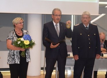 Landrat Harald Altekrüger (Mitte) präsentiert das neue Ärmelabzeichen, das Wolfhard Kätzmer ab Ende Juli tragen wird. Kreistagspräsidentin Monika Schulz-Höpfner (links) gratuliert ebenfalls.