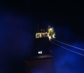 An der Turmspitze angekommen, entzündet es den höchsten Weihnachtsbaum von Forst (Lausitz)