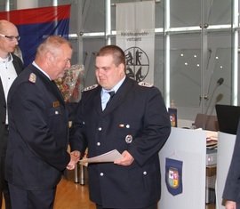 LFV Präsident Werner-Siegwart Schippel gratuliert Stephan Müller für seine Auszeichnung mit dem Ehrenzeichen des Kreis­feuerwehr­verbandes Spree-Neiße e.V.