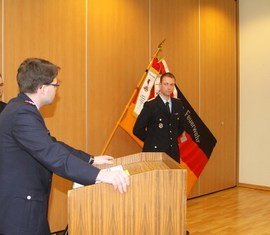 Vorsitzender des Kreis­feuerwehr­verbandes Spree-Neie e.V. verliest die Urkunde zu Auszeichnung des Kam. Martin Gloeckner
