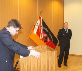 Vorsitzender des Kreis­feuerwehr­verbandes Spree-Neiße e.V. verliest die Urkunde zur Auszeichnung des Kam. Ronny Heppchen