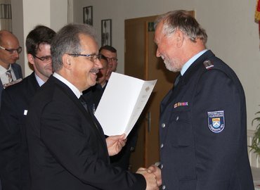 Landrat Harald Altekrüger übergibt die Urkunde an Wilfried Hoffmann