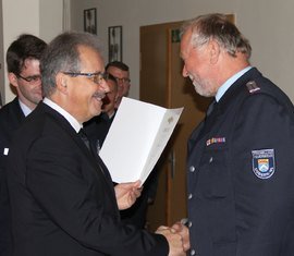 Landrat Harald Altekrüger übergibt die Urkunde an Wilfried Hoffmann